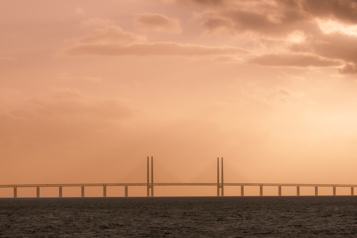 Landskapsbild på ett rapsfält med en blå himmel och moln.